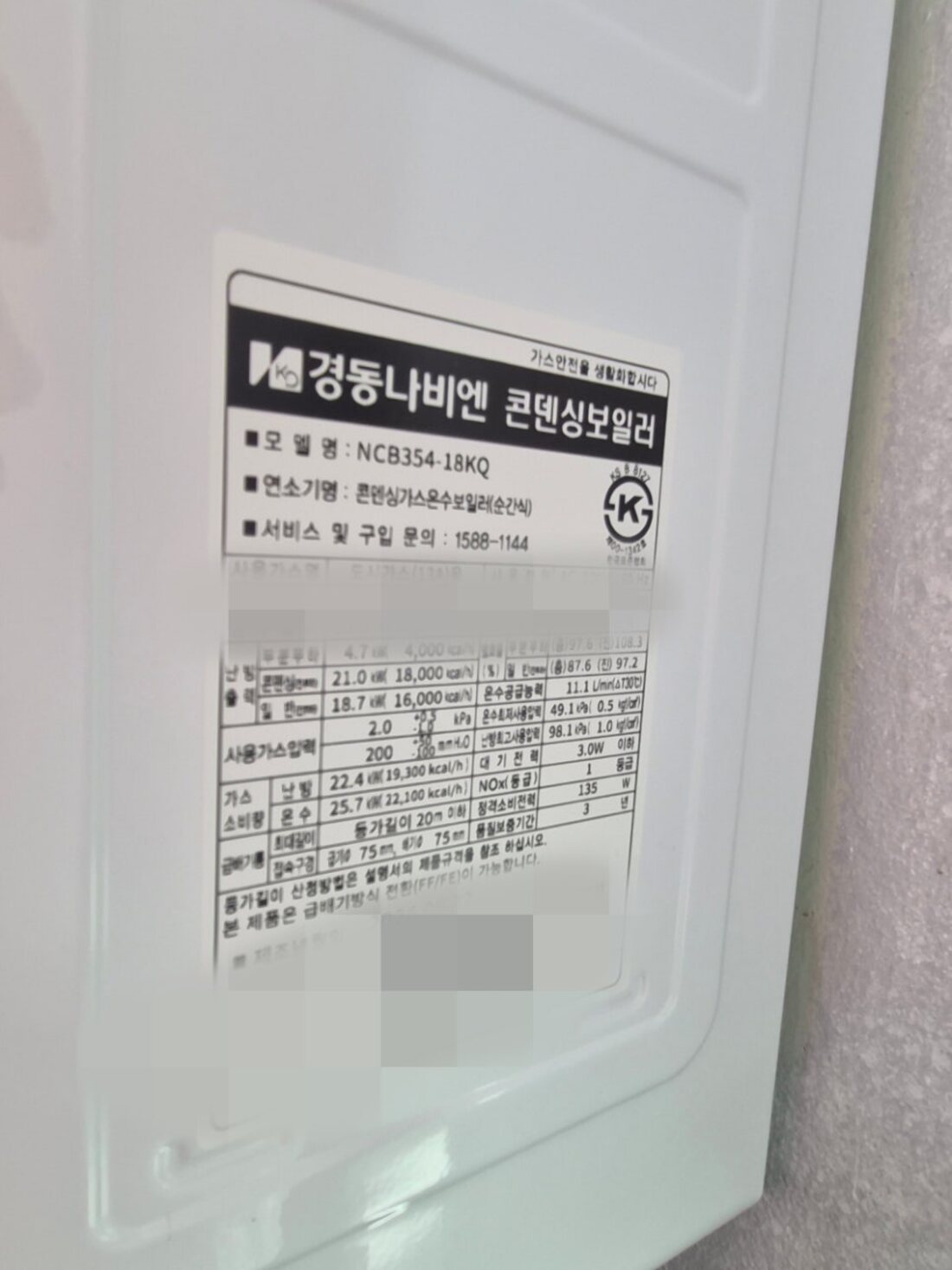보일러 본체 명판으로 설치 모델을 확인하는 모습